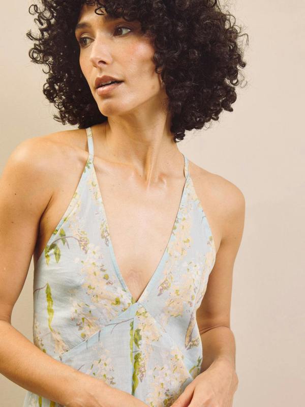 Woman wearing a floral night dress with a neutral background