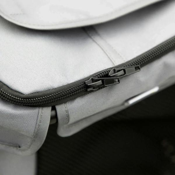 Grey stroller seat close-up of zipper track and pull near padded edge