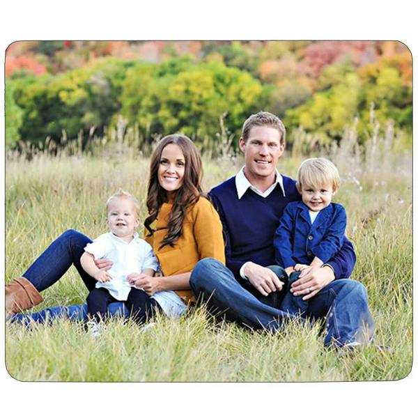 Square mouse mat with rounded corners featuring a family photo of two adults and two children sitting in a grassy field with .