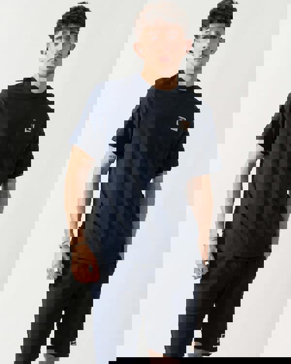 Studio shot of a model wearing an Aquascutum Mens Badge T-Shirt in Navy 11