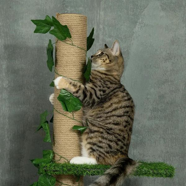 Tabby cat lounging on green artificial grass platform of a leaf-wrapped jute cat tree