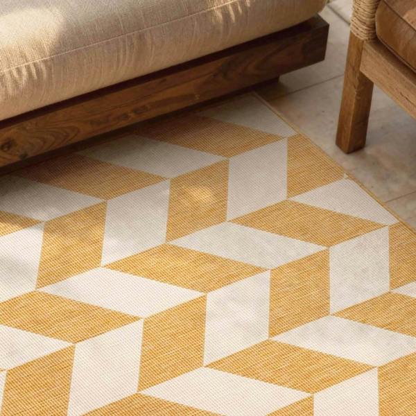 Geometric patterned rug with yellow and white colors on a floor.
