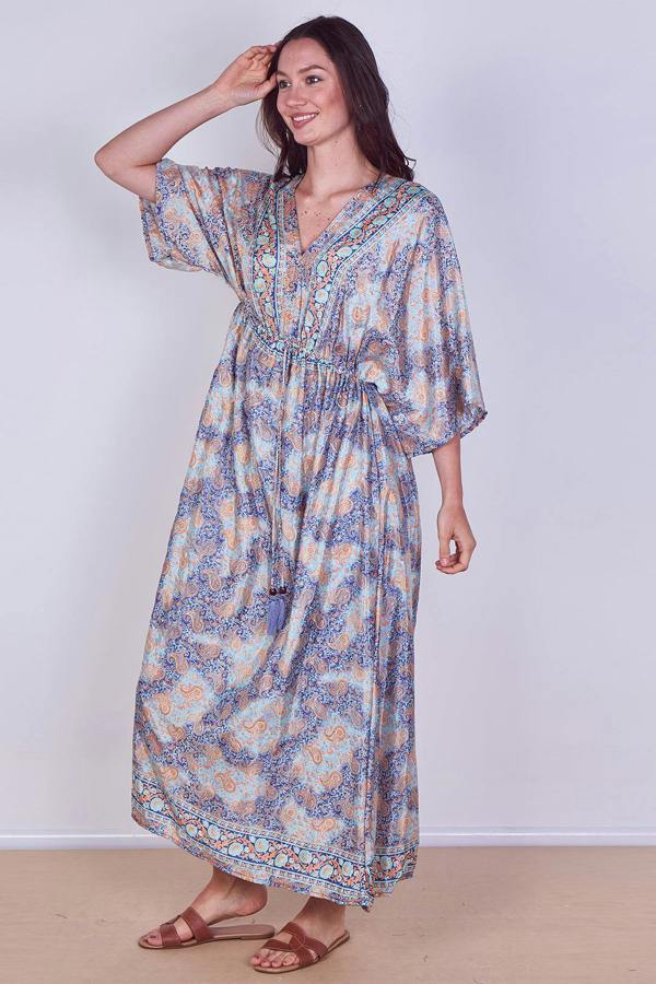 Woman wearing a floral dress against a plain background
