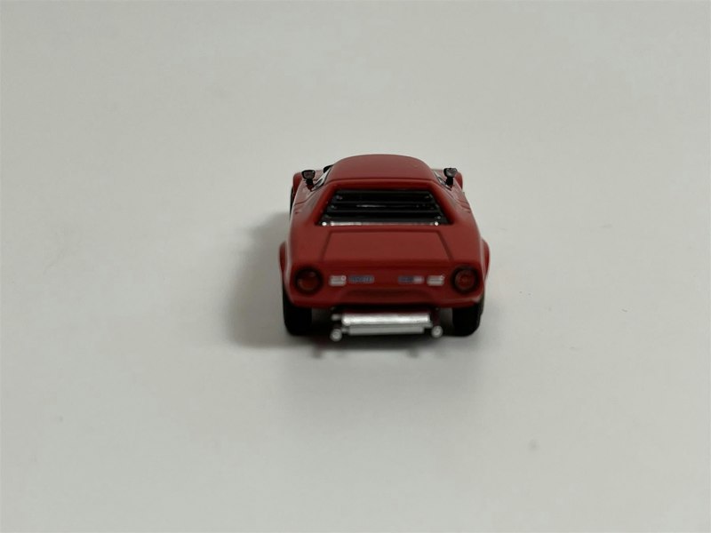 a red toy car on a white surface
