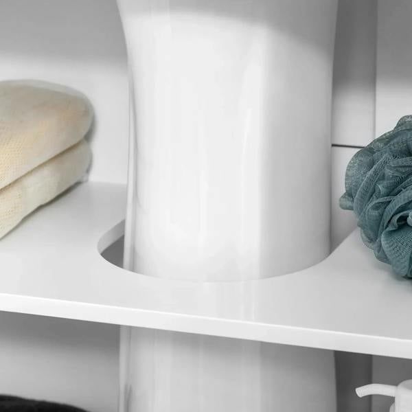White under sink cabinet interior shelf with towels and a round cutout