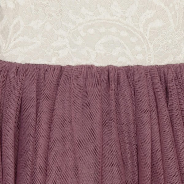 Close-up of a dress with a white lace top and purple skirt.