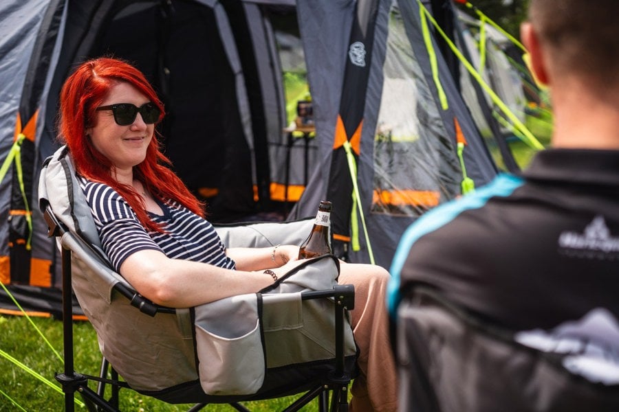 A male and a female sat on camping chairs outside of the Abberley Xl Breeze® 4 Berth Inflatable Tent from OLPRO.