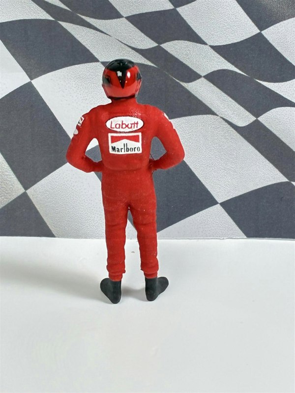 a toy figure of a man wearing a race car suit
