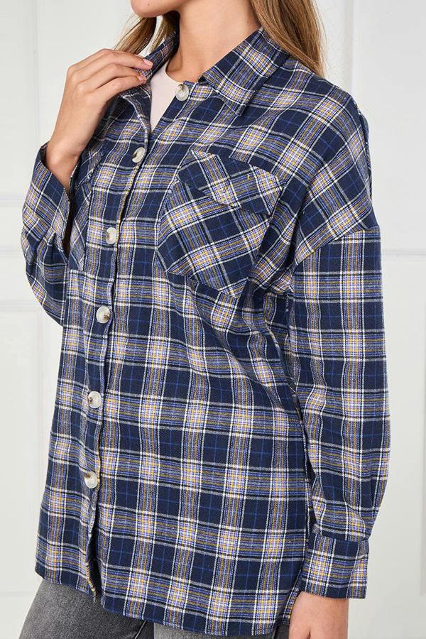 Person wearing a blue and yellow plaid shirt against a white background