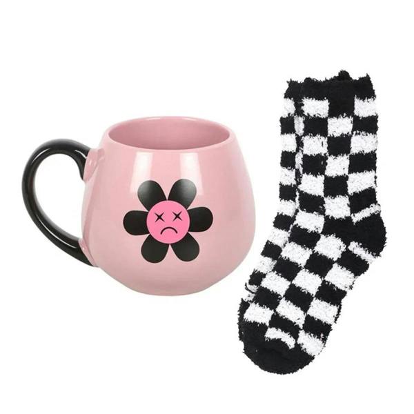 Pink mug with sad flower graphic and black-and-white checker socks pair