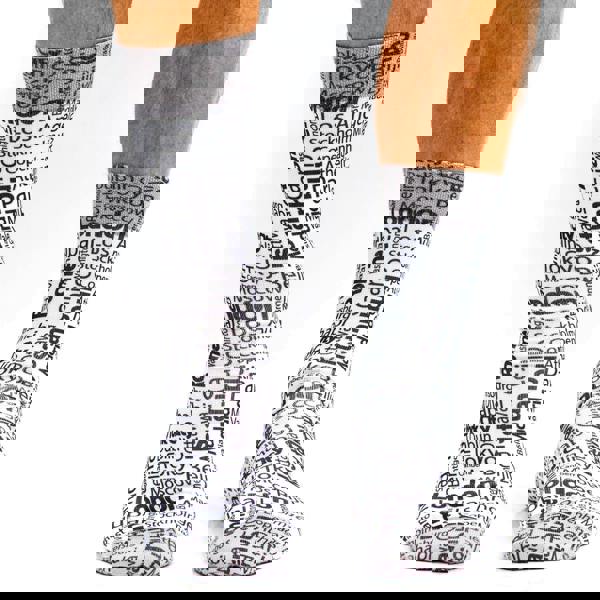 Socks with city names printed on them worn by a person.