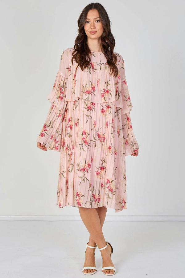 Woman wearing a pink floral dress against a white background