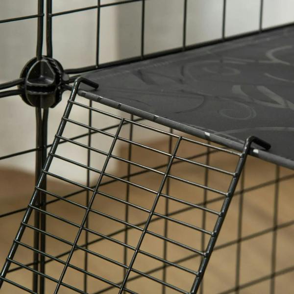 Close-up of dark resin floor mat secured on a black wire playpen frame