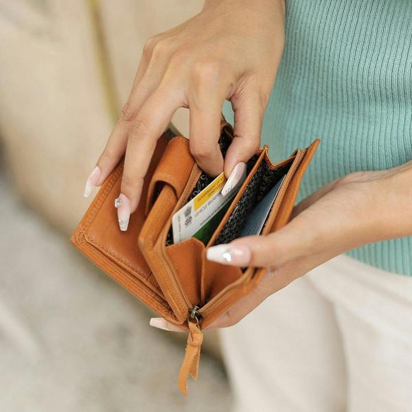 Cognac Paloma medium trifold purse in washed Cancun leather held in hand