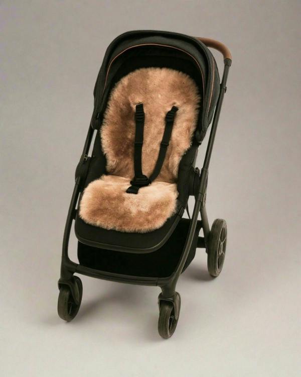 Black stroller with a rose gold sheepskin seat cover
