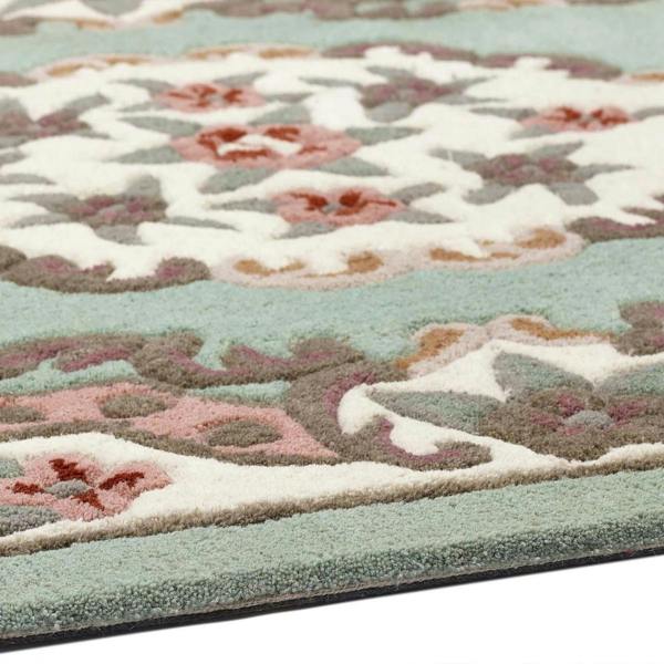 Close-up of a floral patterned rug with pastel colors on a white background
