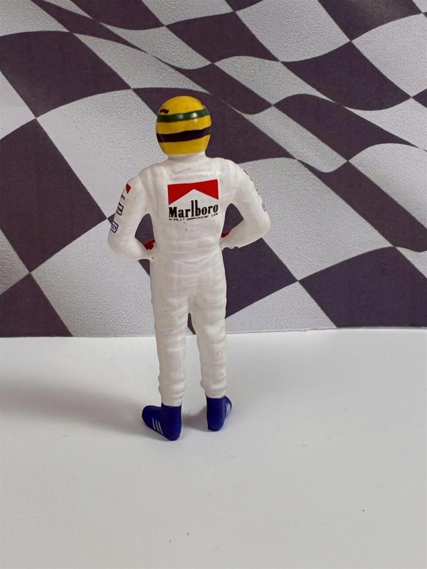 a toy figure of a man wearing a race suit