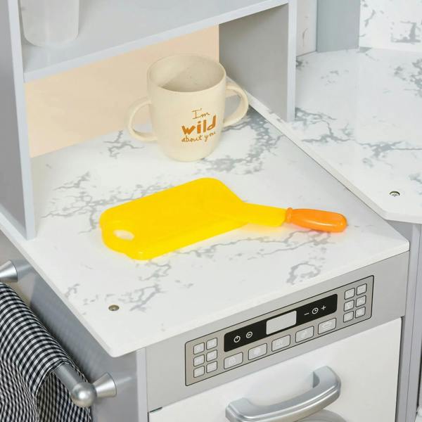 Toy kitchen countertop with mug and yellow spatula, next to grey control panel