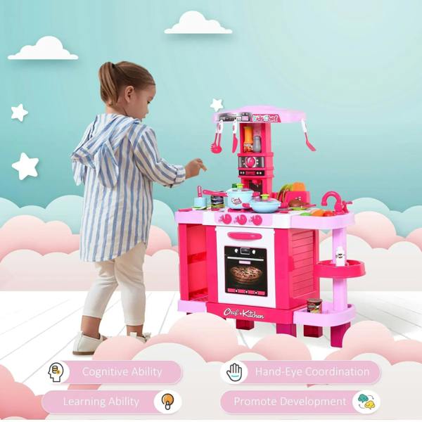Child playing with pink kids kitchen play set featuring stove, oven, and hanging tools.