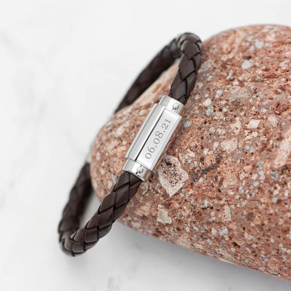 Personalised men's brown braided leather bracelet wrapped around a terracotta stone, featuring a stainless steel plate engraved with the date 06.08.21