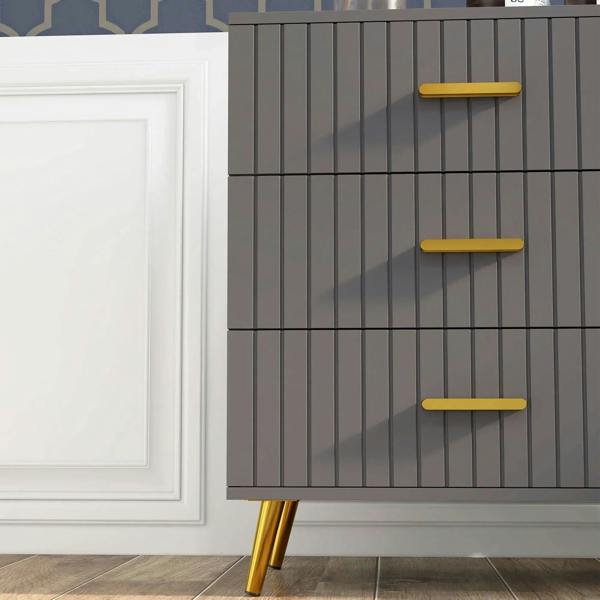 Close-up of dark grey dresser front with embossed vertical lines and gold-tone drawer bar handles
