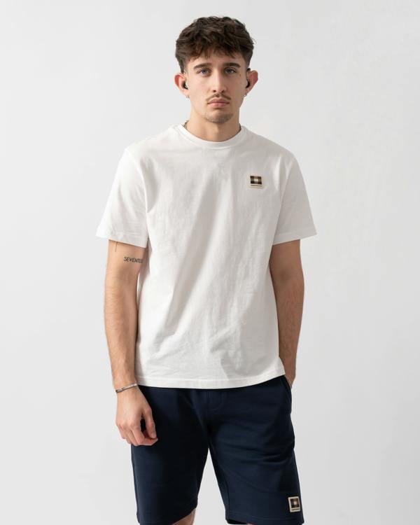 studio shot of a model wearing an Aquascutum Mens Badge T-Shirt in Old White