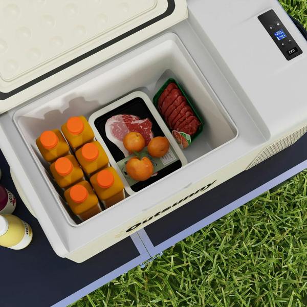 Open khaki and grey car fridge interior with orange bottles and food containers