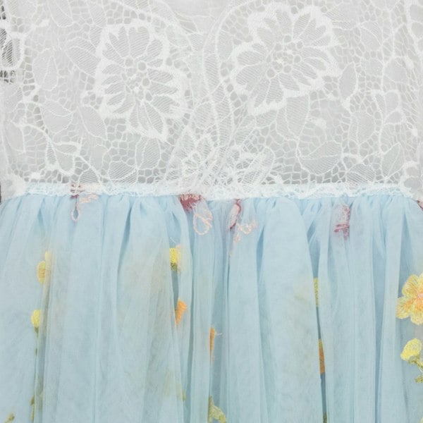 Light blue tulle skirt with floral embroidery on a white lace background