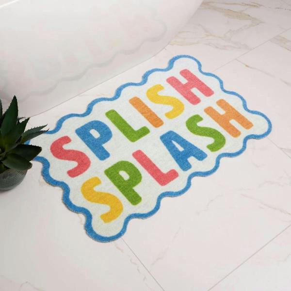 Colorful bath mat with 'Splish Splash' text on a tiled floor.
