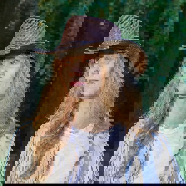 woman wearing a wombat the wilds air brown leather hat with mesh sides