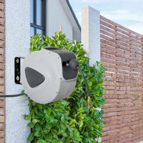 Light gray retractable air hose reel on exterior wall with attached hose