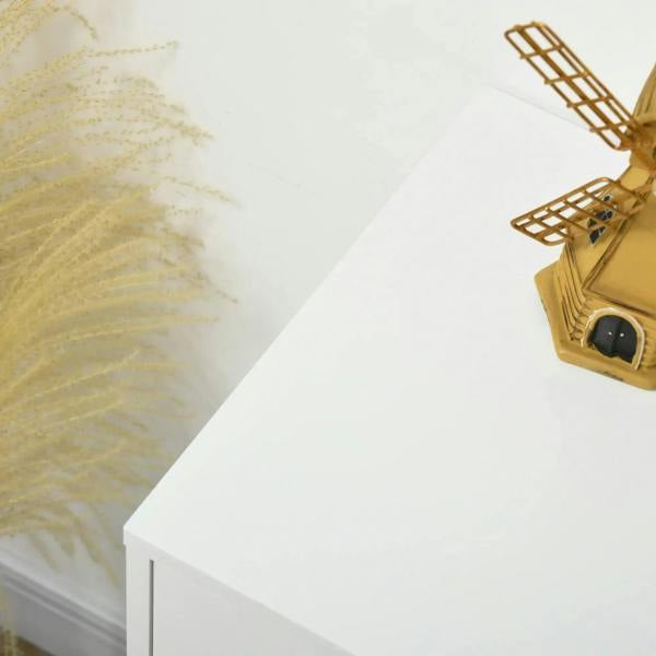 White drawer top corner with gold hairpin leg and hardware detail on a tall 4-drawer dresser.
