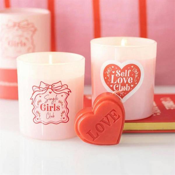 Two candles with Self Love Club heart logo and red LOVE wax seal