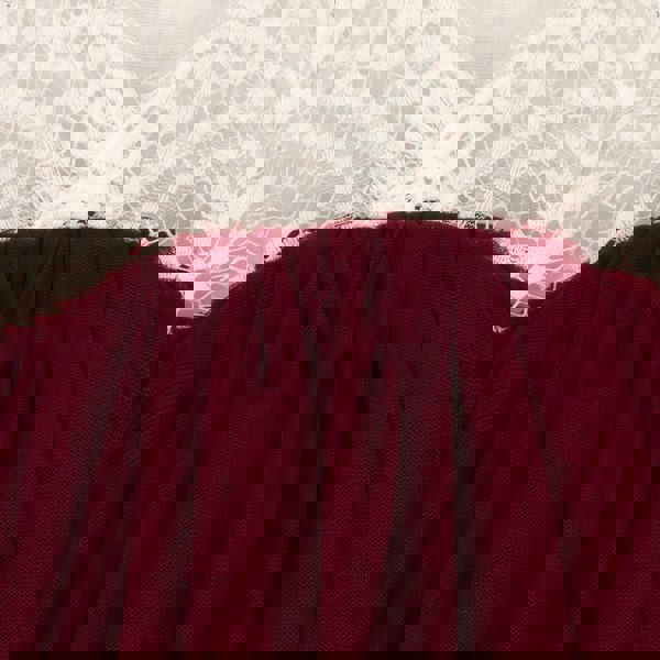 Close-up of a burgundy fabric with lace trim in the background