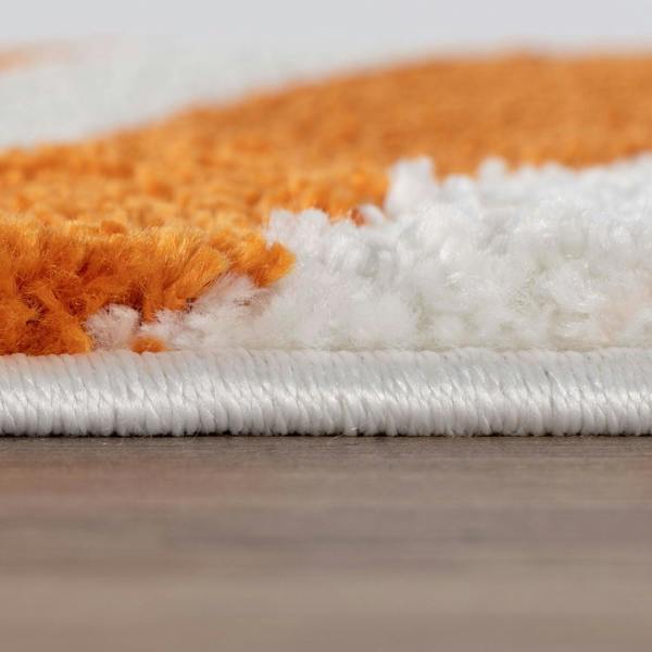Close-up of an orange and white striped rug on a wooden floor.