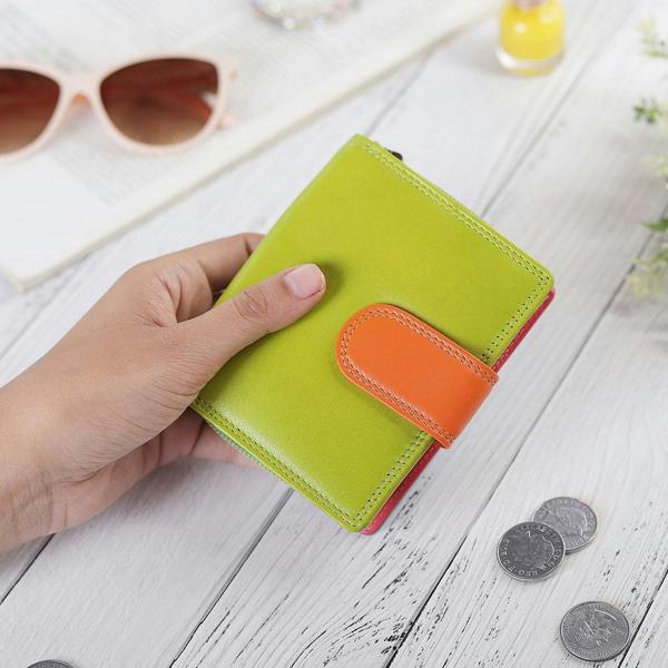 Green leather purse placed with daily essentials for a lifestyle view