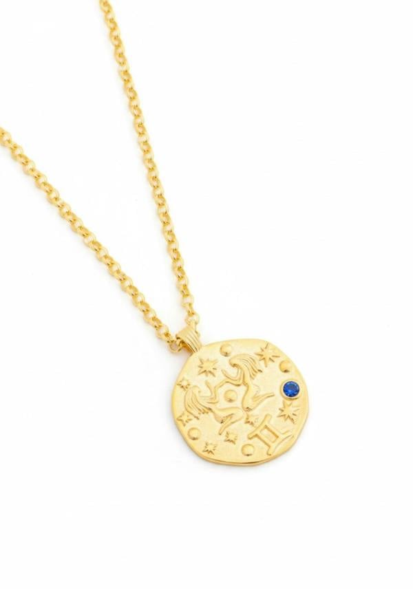 Gold necklace with a round pendant on a white background
