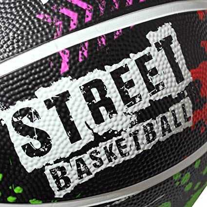 Close-up of white STREET BASKETBALL graffiti logo on black paint-splattered ball surface - Optimum