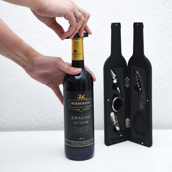 Close-up action shot of a hand using the black foil cutter tool on a red wine bottle neck to cleanly remove the protective capsule.