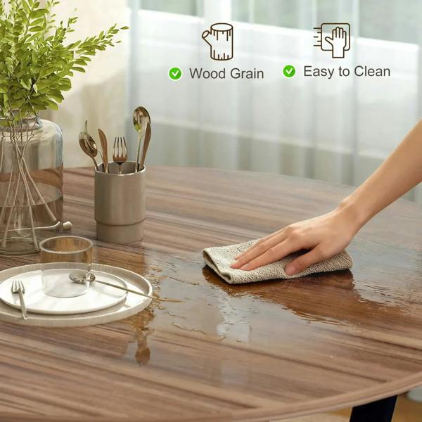 Round brown wood dining table top being wiped clean with a cloth