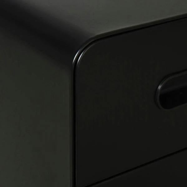 Close-up of black file cabinet drawer front with curved handle opening