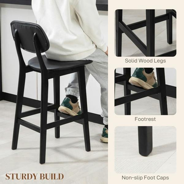 Black bar stool with faux-leather seat, solid wood legs, and lower footrest support