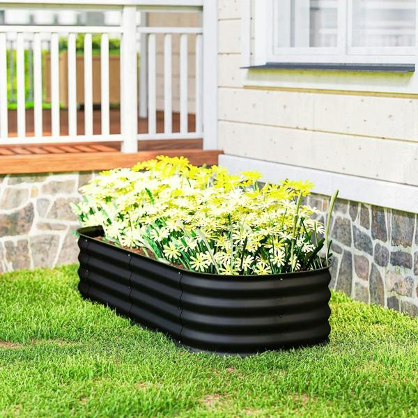 Black galvanized raised garden bed planter box with green herbs on a lawn