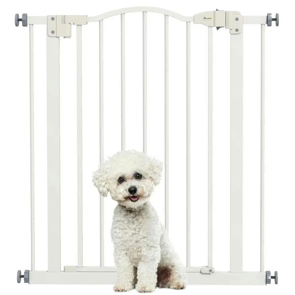 White vertical pet gate with auto-close door and small white dog behind bars