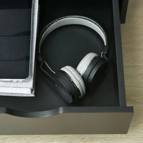 Black filing cabinet drawer with black over-ear headphones inside
