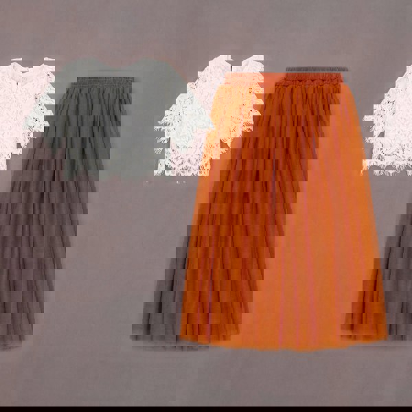 White lace top and orange tulle skirt on a grey background