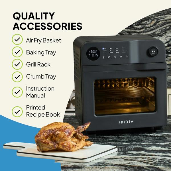 A black Fridja f66 Super Oven - 15L Digital Air Fryer Oven sits on a kitchen counter by a cutting board with roast chicken. Listed: PFAS free air fry basket, baking tray, grill rack, crumb tray, manual, and recipe book included.