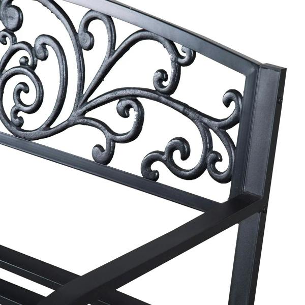 Close-up of black steel scrollwork backrest on a garden bench