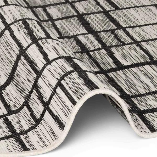 Close-up of a black and white checkered rug on a white background