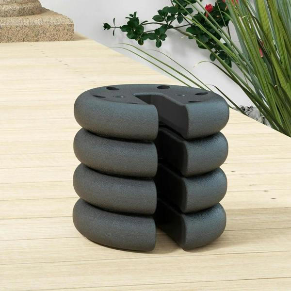 Stack of dark gray tent leg weights on wooden deck with top mounting holes
